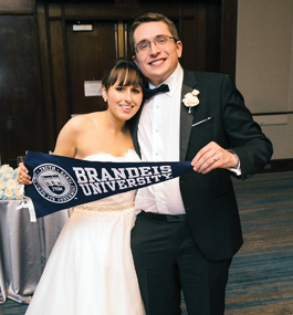 Arielle Schwartz and Rick Alterbaum hold a Brandeis pennant at their wedding